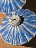 Floating Blue ceramic bauble seen from above, cobalt glaze radiating along the pleats from the silver-tone cap.