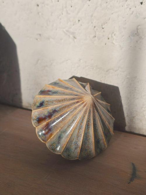 Amber Blue Ribbed Diamond ceramic bauble, the pleated ridges fanning out from the point, glaze in soft blue, amber and plum.